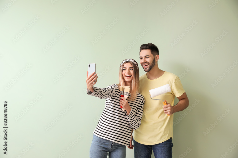 Happy young couple taking selfie during repair in their new house