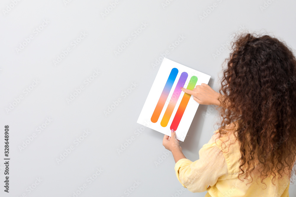 African-American woman with color palettes on grey background