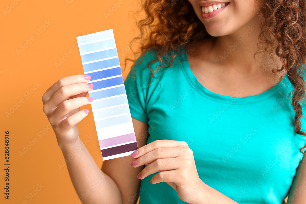 African-American woman with color palette on orange background