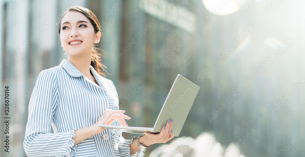 迷人的聪明漂亮的亚洲女性穿着得体的通信智能手机和笔记本电脑与开朗