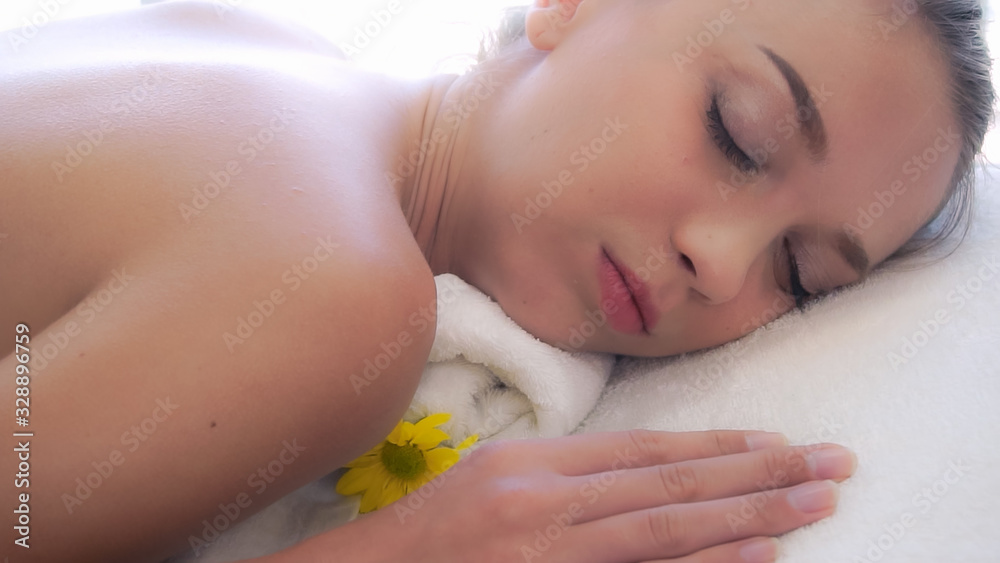 Relaxed woman getting back massage in luxury spa with professional massage therapist. Wellness, heal