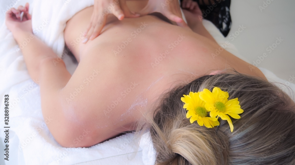 Relaxed woman getting back massage in luxury spa with professional massage therapist. Wellness, heal