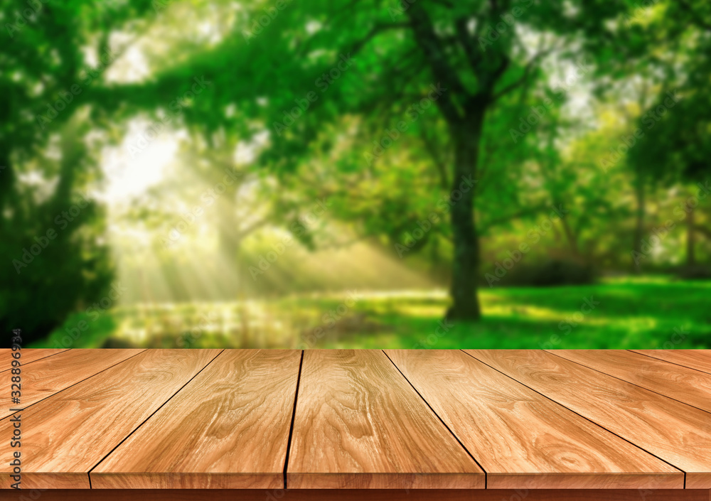 Brown wood table in green blur nature background of trees and grass in the park with empty copy spac