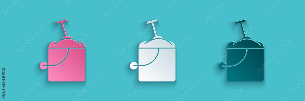 Paper cut Sand in bucket with shovel icon isolated on blue background. Plastic kid toy. Summer icon.