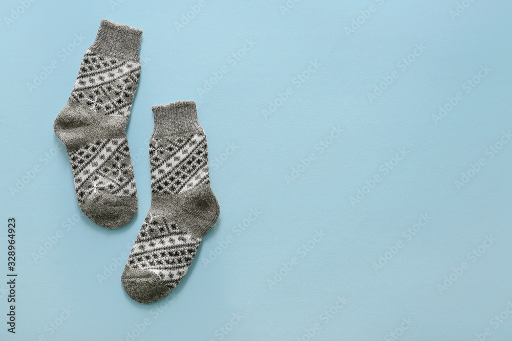 Knitted socks on color background