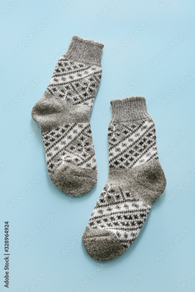 Knitted socks on color background