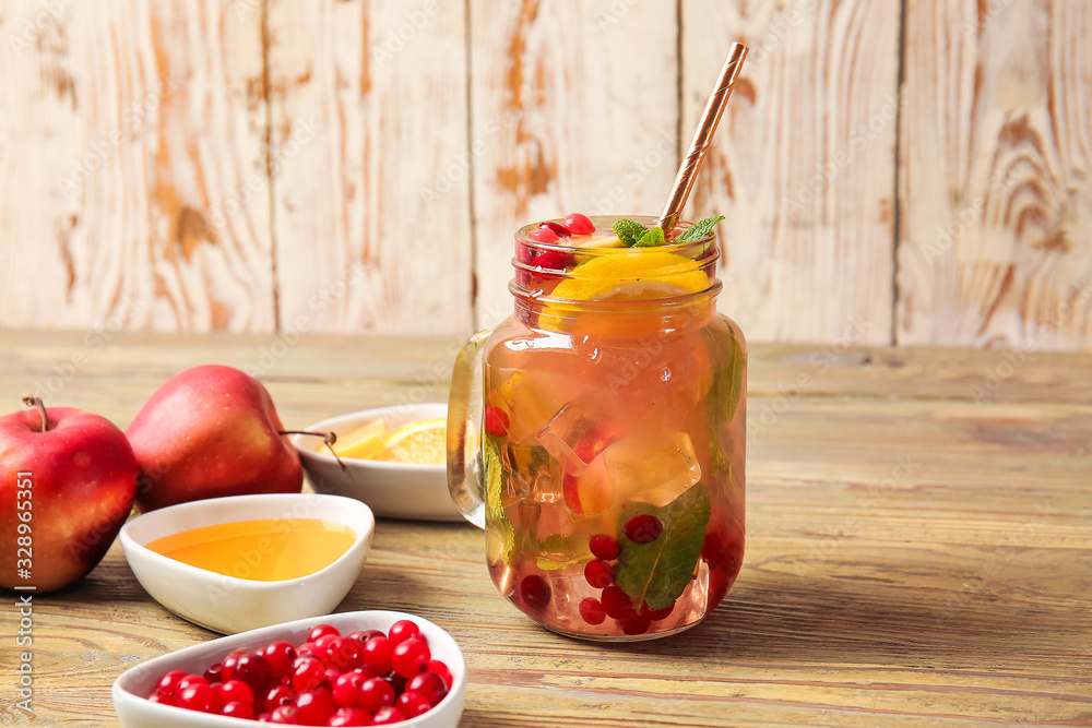 Mason jar of cold tea and ingredients on wooden table