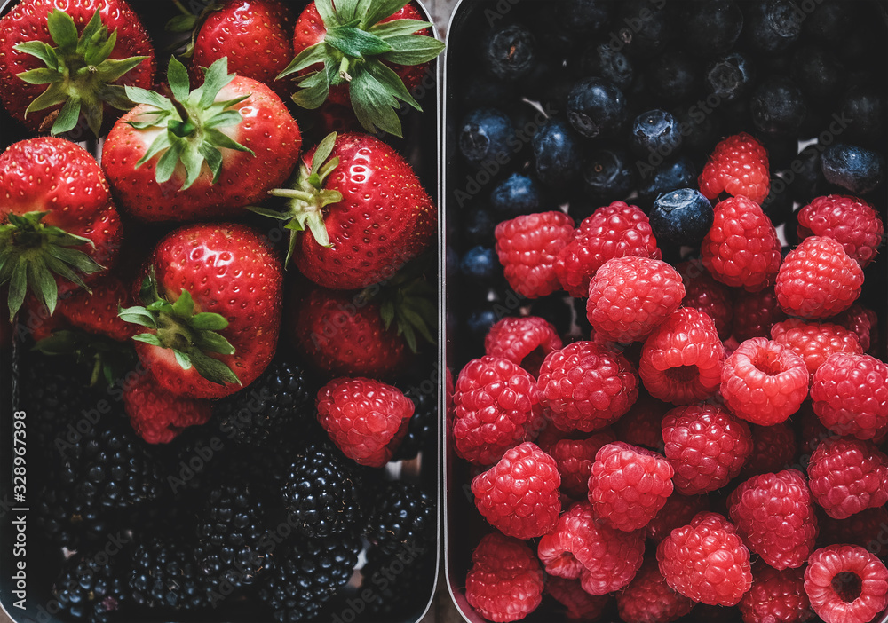 Healthy summer vegan lunch. Flat-lay of fresh seasonal strawberries, raspberries, blueberries and bl