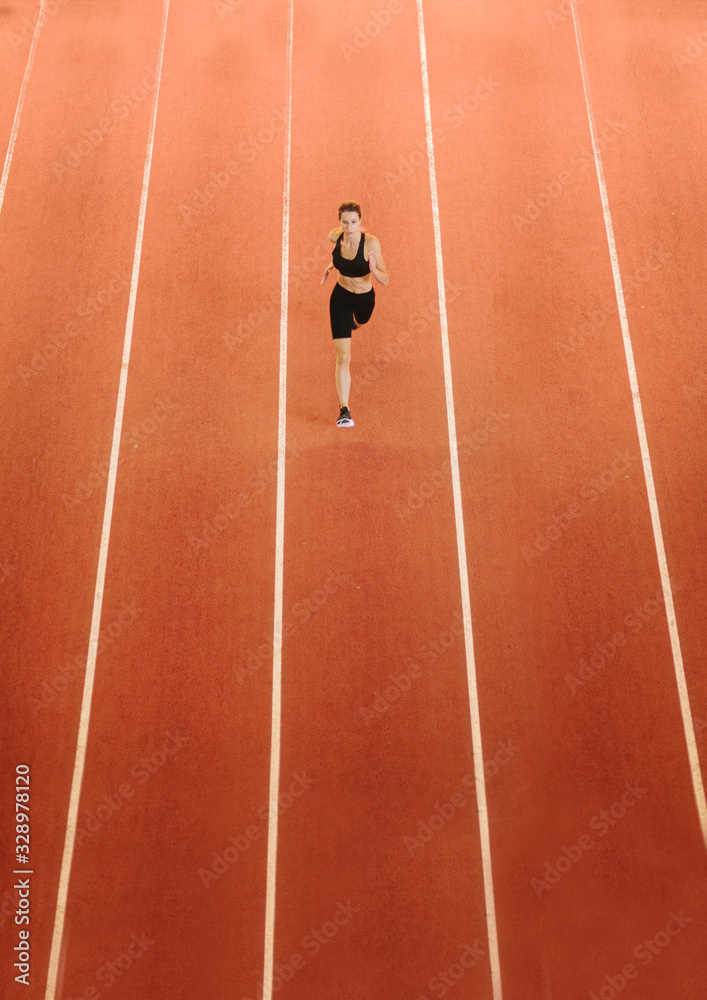 sportswoman running on road on stadium