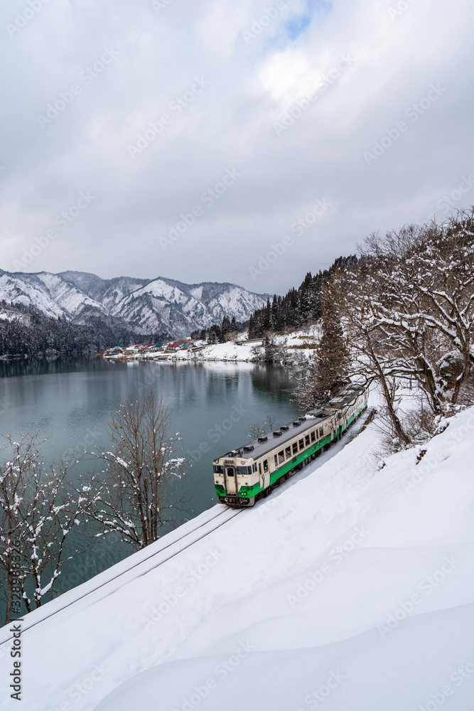 Beautiful landscape of Tadami line train across Tadami river in winter at Fukushima, Japan