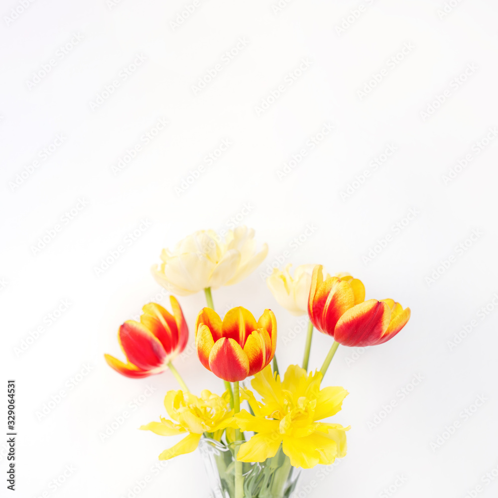 Tulip flower in glass vase with picture frame place on white wooden table background against clean w