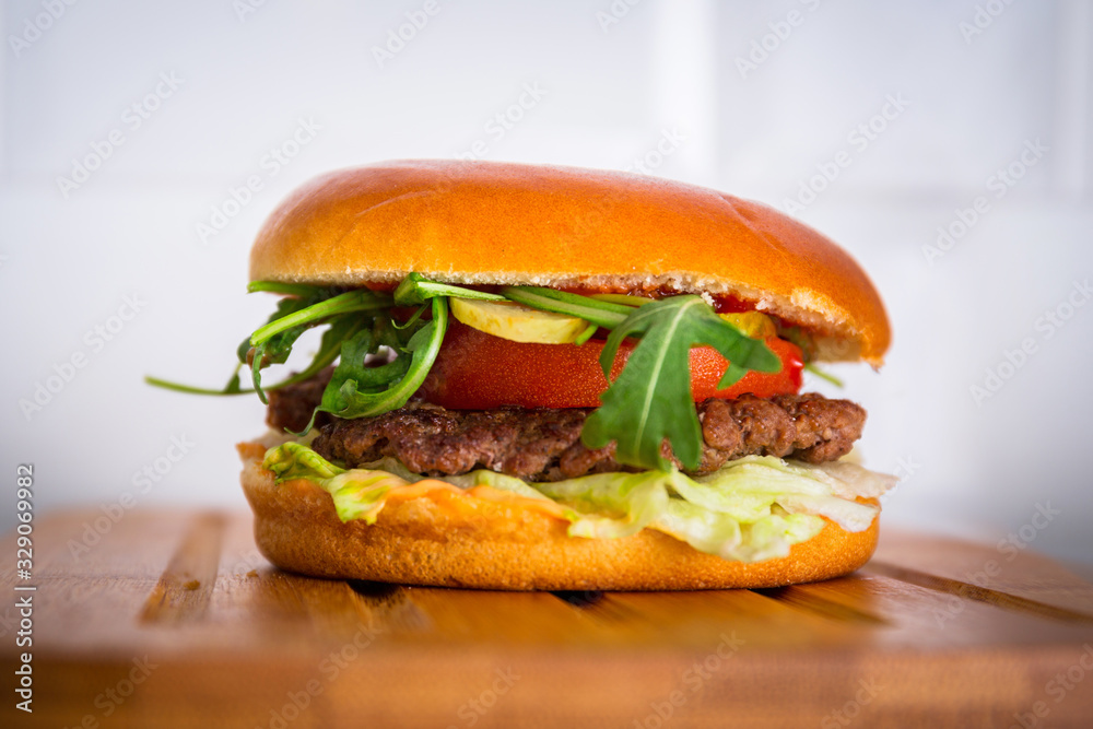 Homemade hamburger on wooden cutting board