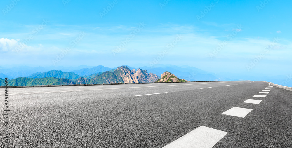 Empty asphalt road and green mountain with beautiful clouds,panoramic view.