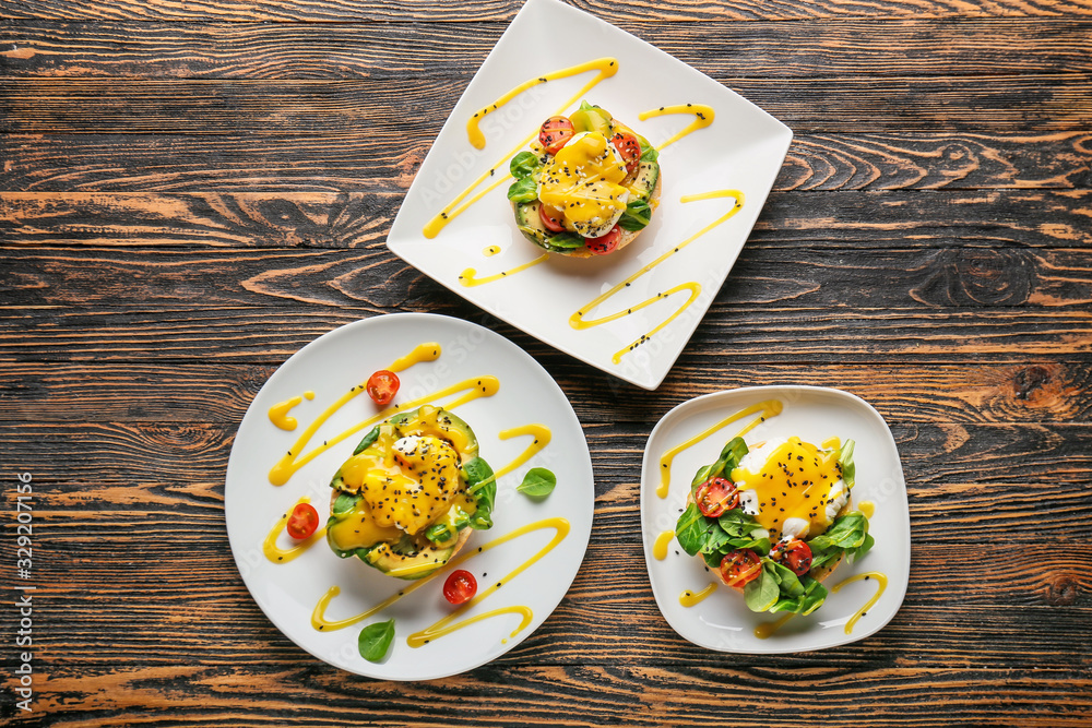 Tasty eggs Benedict on wooden background