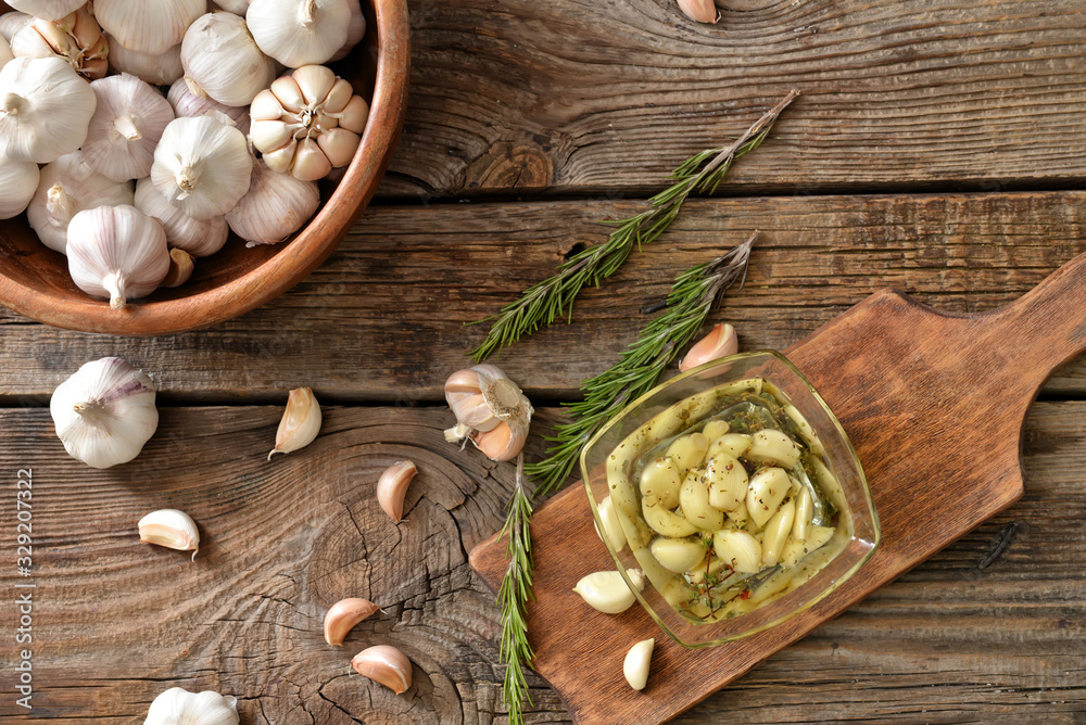 Bowl with garlic and oil on wooden table