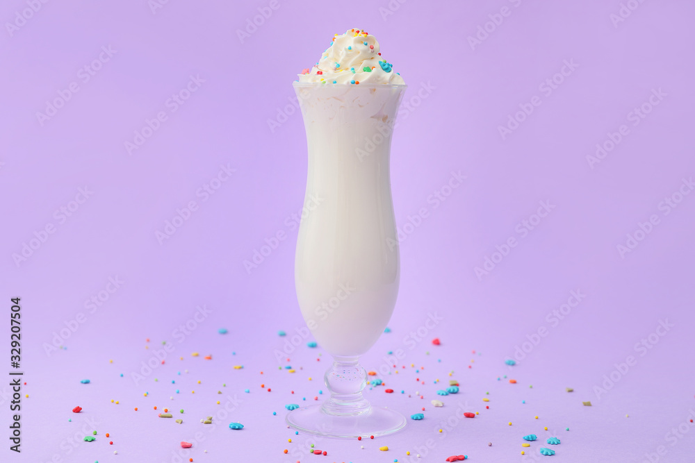 Glass of tasty milkshake on color background