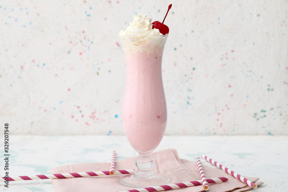 Glass of tasty milkshake on white background