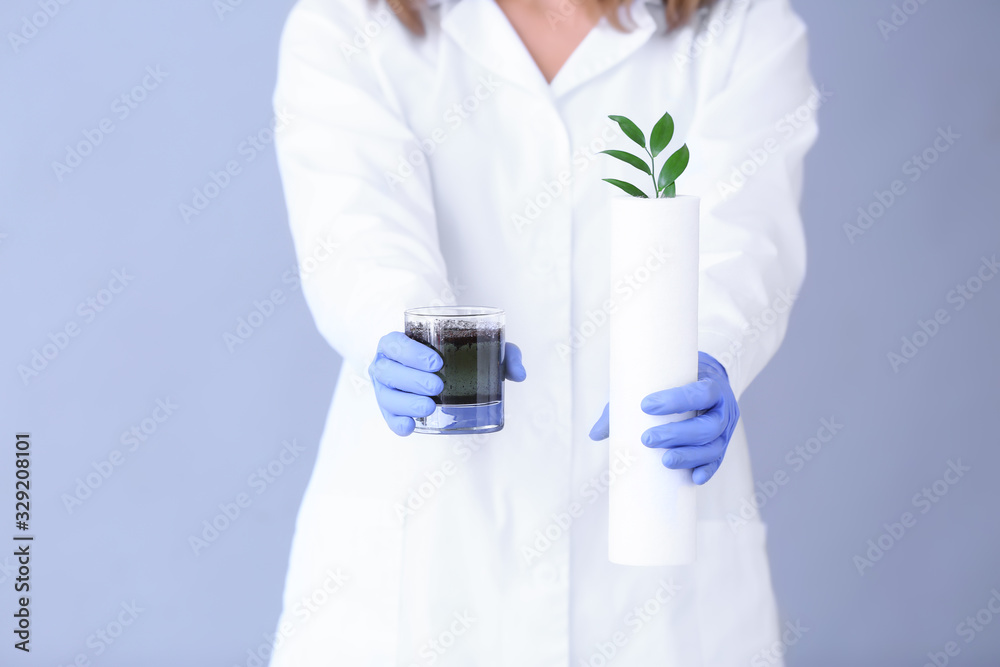 Female doctor with glass of dirty water and filter on color background, closeup