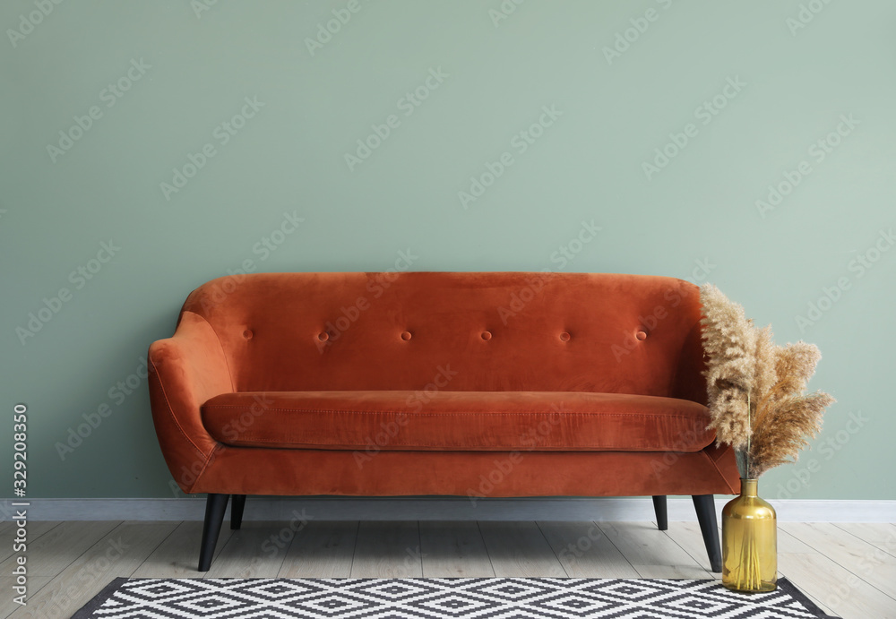 Comfortable sofa near color wall