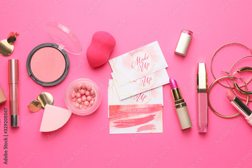 Decorative cosmetics and accessories with business cards of makeup artist on color background