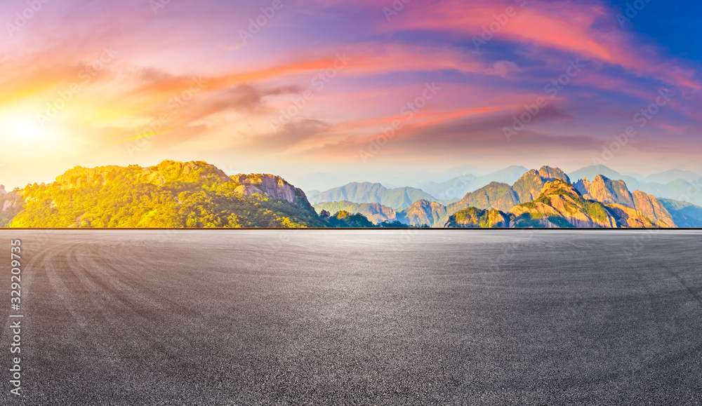 Empty race track road and green mountain with beautiful clouds at sunrise,panoramic view.