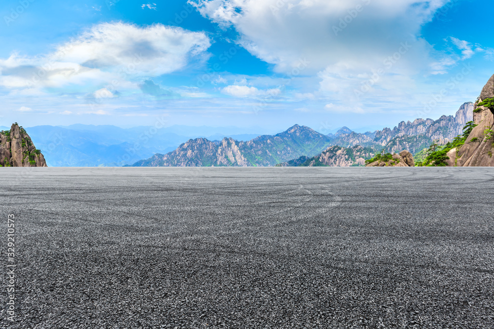 Empty race track road and green mountain with beautiful clouds.