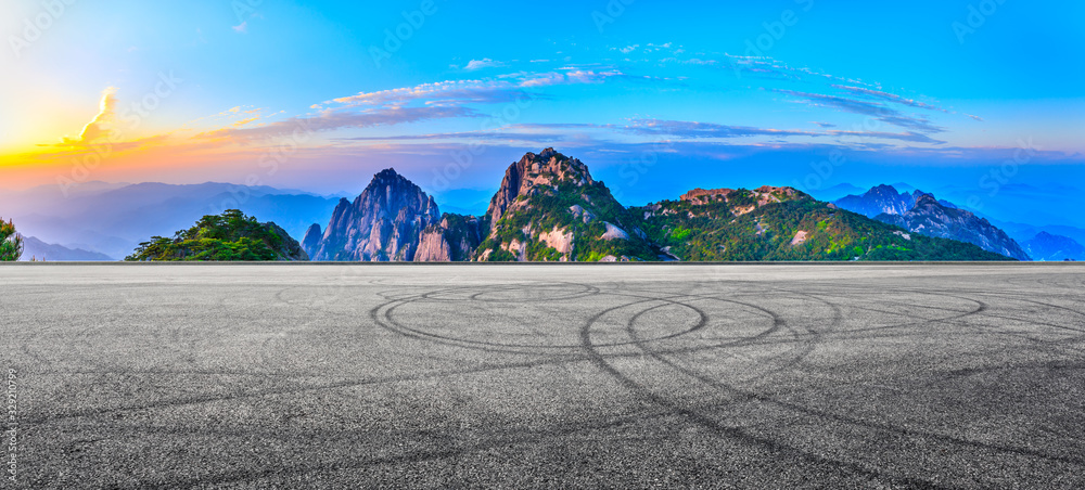 空旷的赛道和青山，日出时有美丽的云朵，全景。