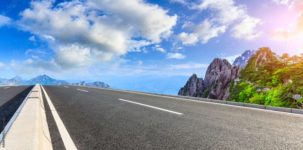 Empty asphalt road and green mountain with beautiful clouds,panoramic view.