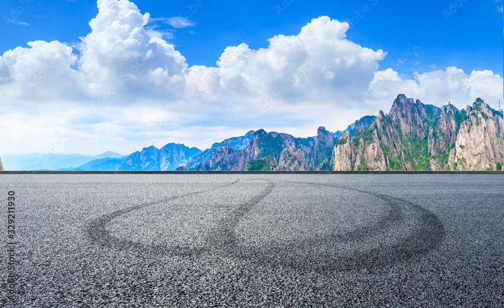 Empty race track road and green mountain with beautiful clouds,panoramic view.