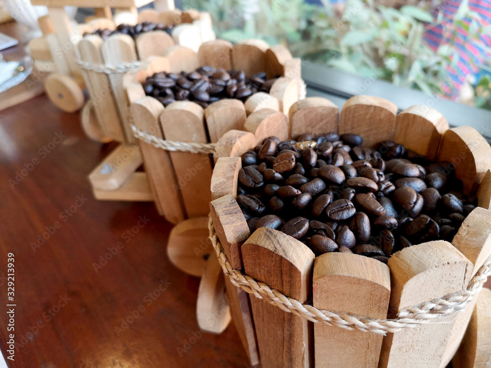 Wooden buckets with coffee beans blurred the background