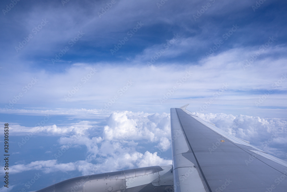 wing of airplane flying above clouds