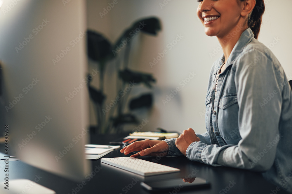 Smiling businesswoman working on a computer at her desk