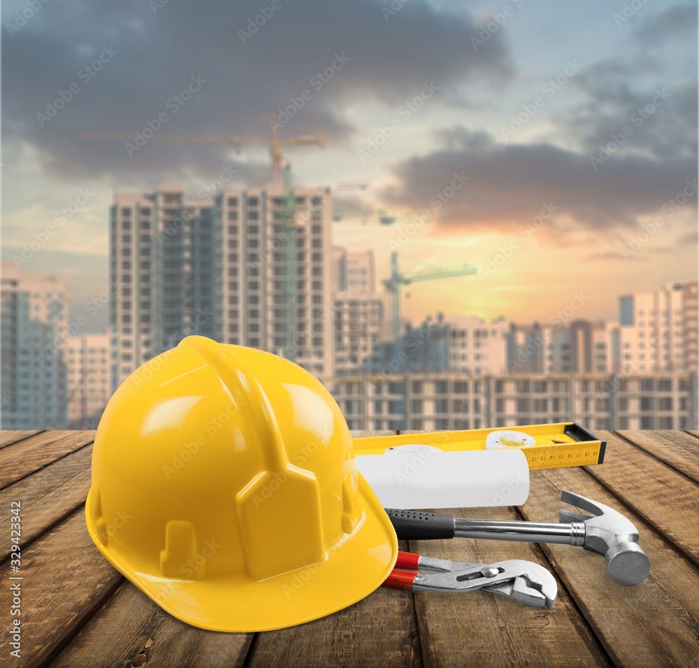 Safety yellow helmet with tools on the desk