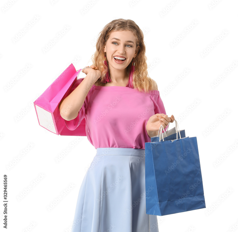 Beautiful young woman with shopping bags on white background