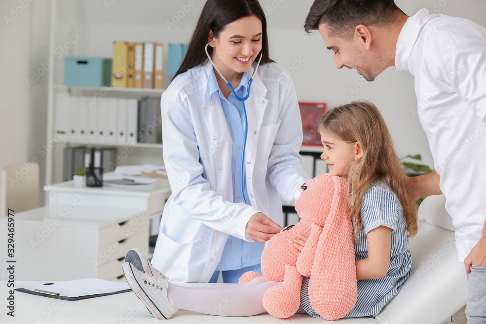 Man with little daughter visiting pediatrician in clinic