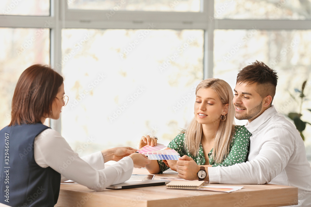 Female interior designer working with couple in office