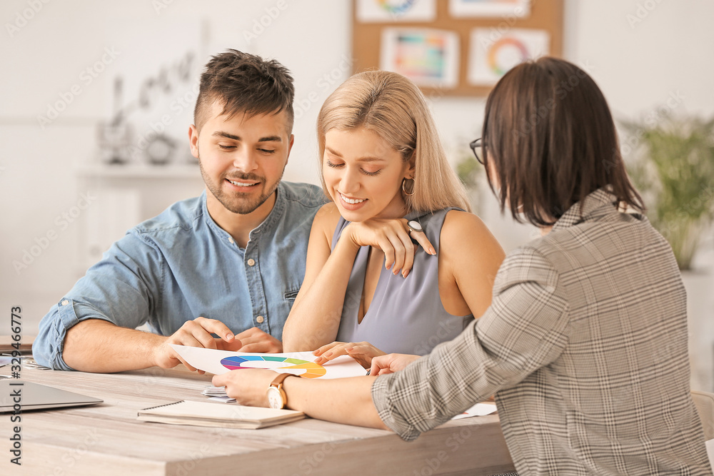 Female interior designer working with couple in office