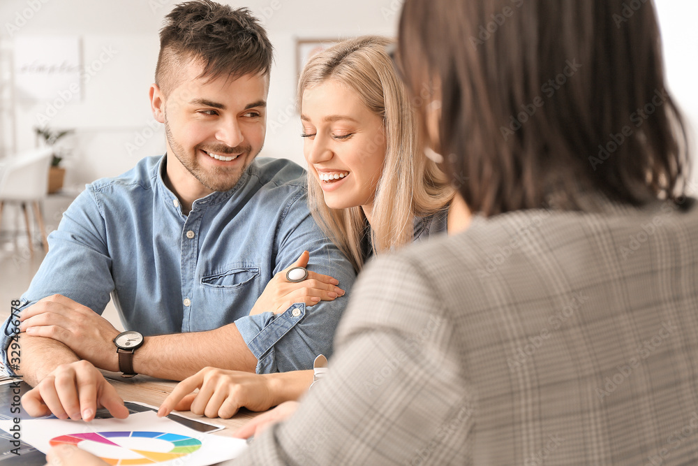 Female interior designer working with couple in office