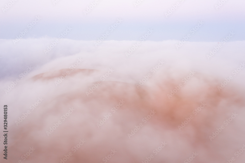 Massive sand dune emerging from a dense fog cloud. Liwa desert, Abu Dhabi, United Arab Emirates.