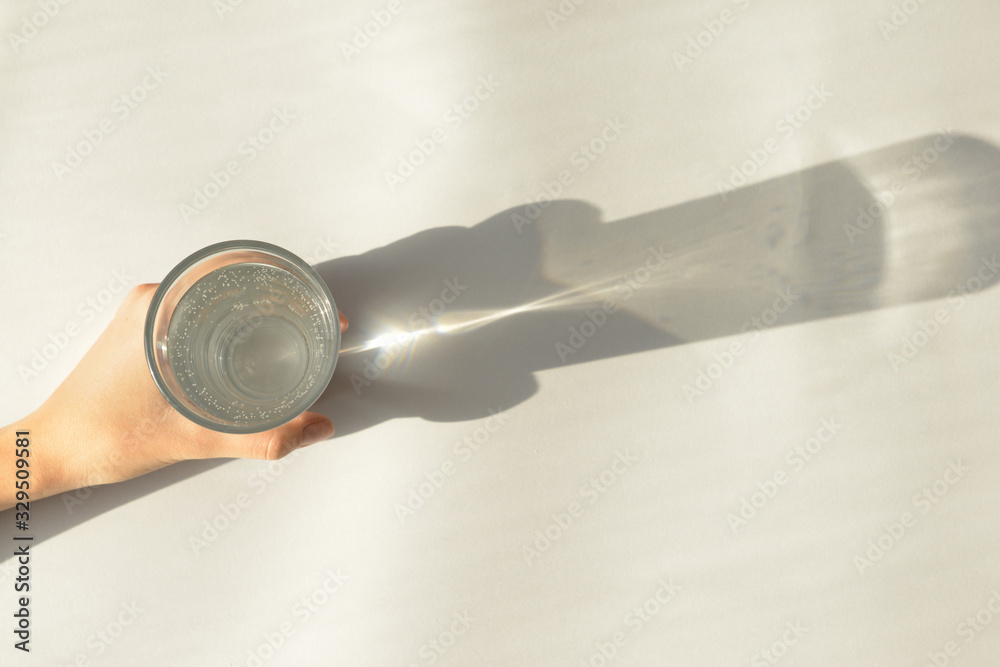 Female hand with glass of water on white background