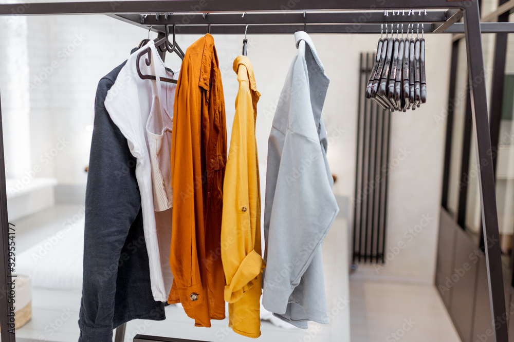 Hanger with colorful casual clothes in bedroom