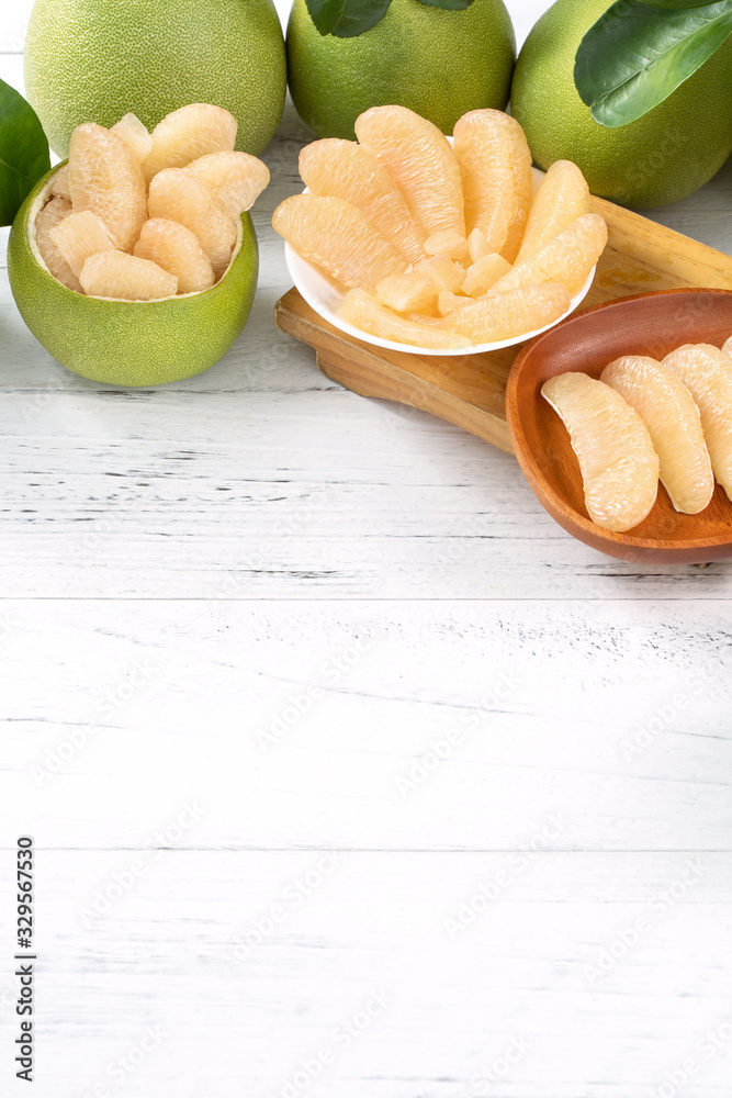 Fresh peeled pomelo, pummelo, grapefruit, shaddock on bright wooden table background. Seasonal fruit