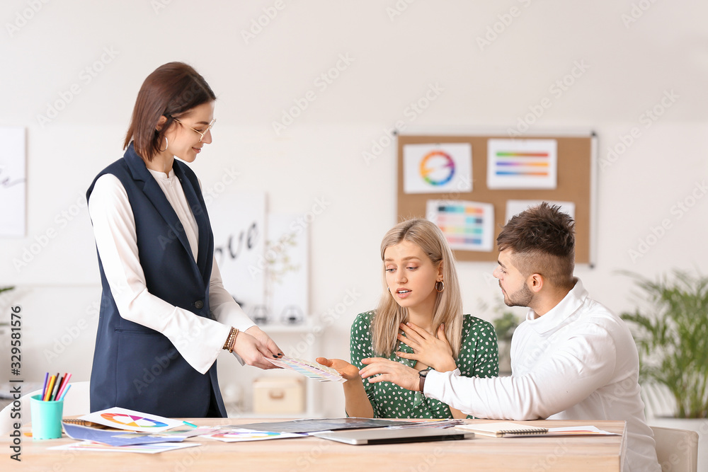 Female interior designer working with couple in office