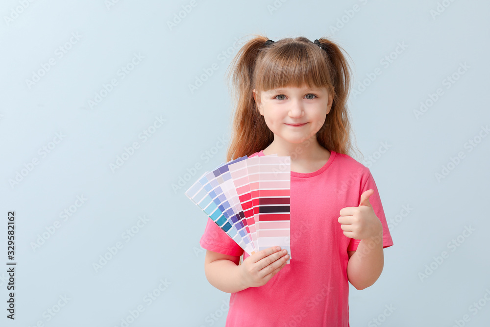 Little girl with color palettes on blue background