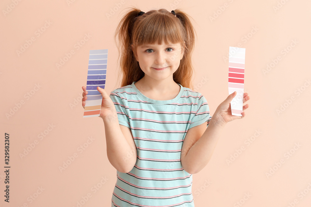 Little girl with color palettes on pink background