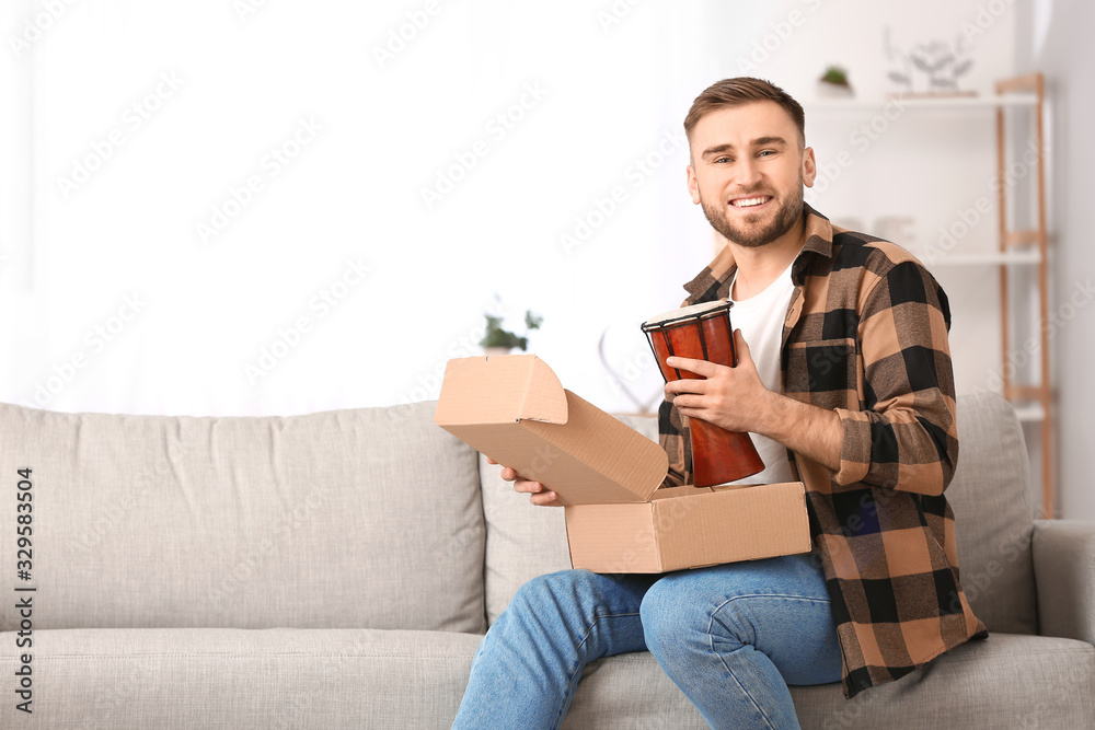 Young man unpacking parcel at home