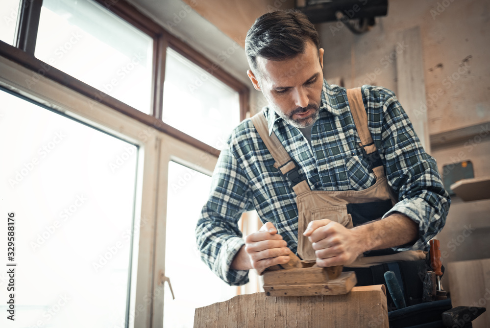 Carpenter working on woodworking in carpentry workshop