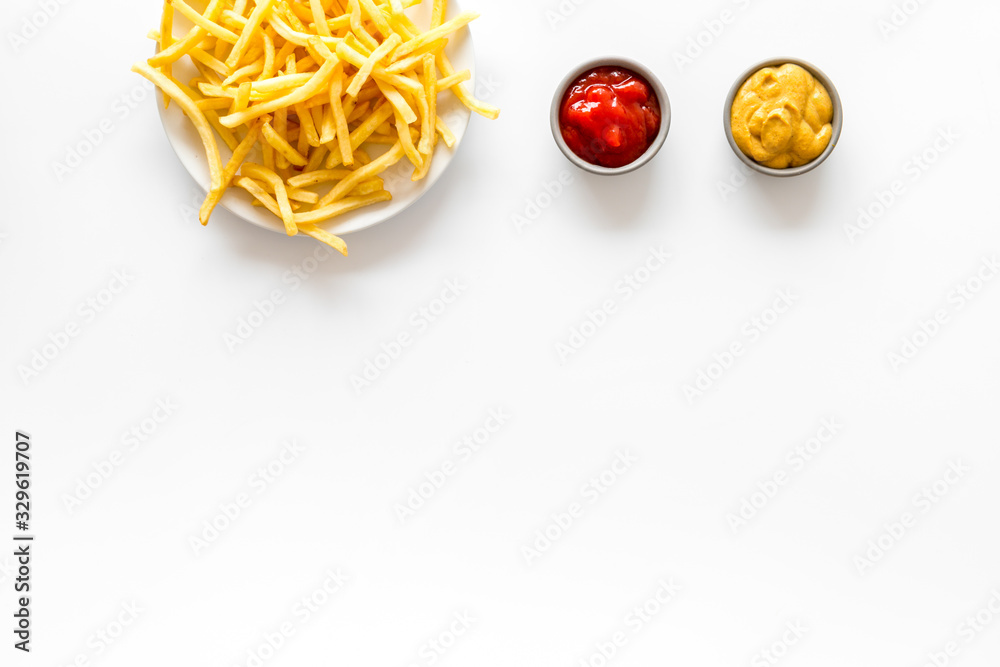 Potato chips on plate near sauces on white table top-down copy space