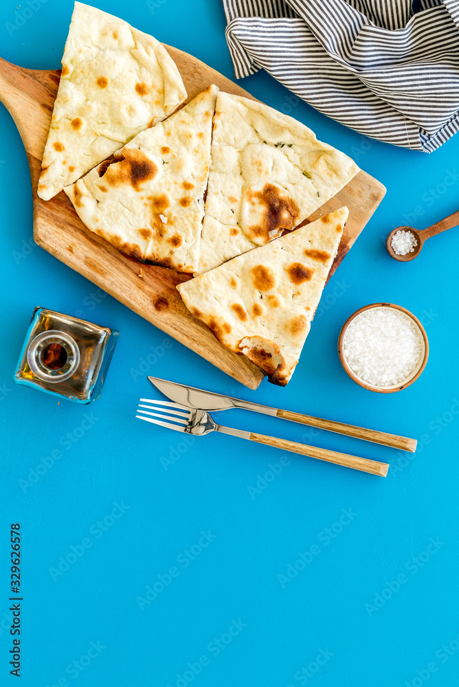 制作focaccia。蓝色桌子上的传统意大利面包自上而下的复制空间