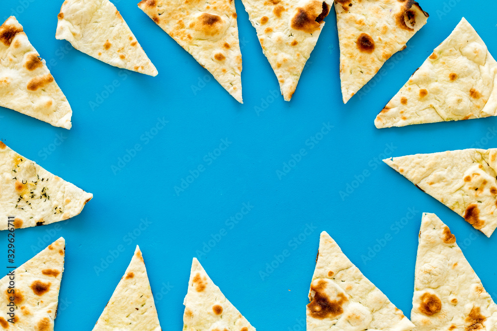 Focaccia pieces frame on blue background top-down copy space